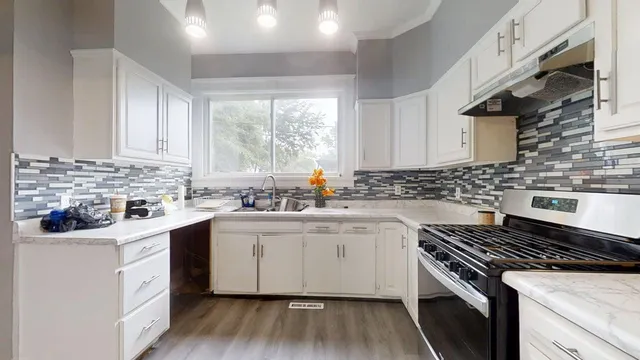 a kitchen with cabinets appliances a sink and a window