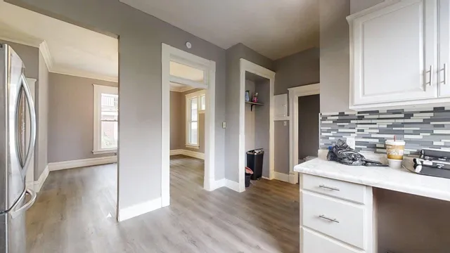 a kitchen with stainless steel appliances white cabinets and wooden floor