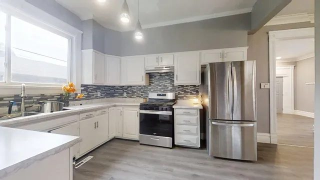a kitchen with stainless steel appliances granite countertop a refrigerator stove and sink