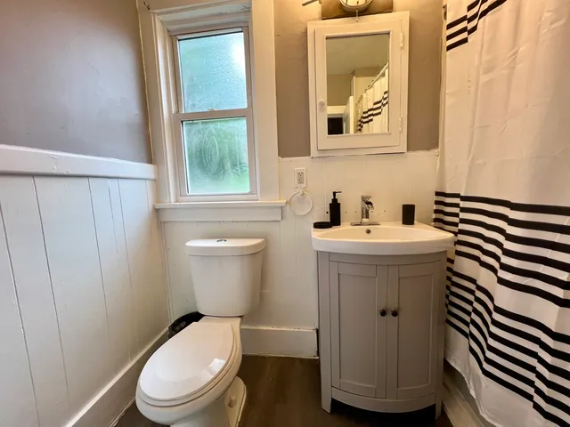 a bathroom with a sink a toilet and a window