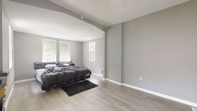 a spacious bedroom with a bed and a window