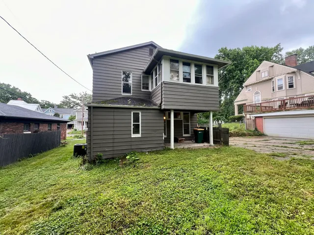 a view of a house with a yard and sitting area