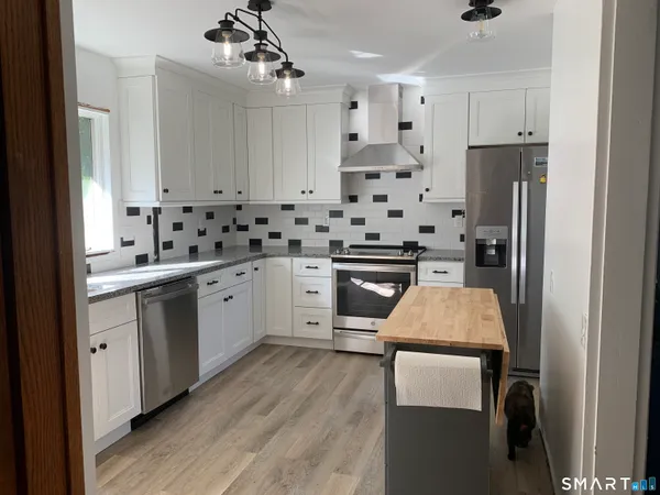 a kitchen with stainless steel appliances a stove a sink and a refrigerator