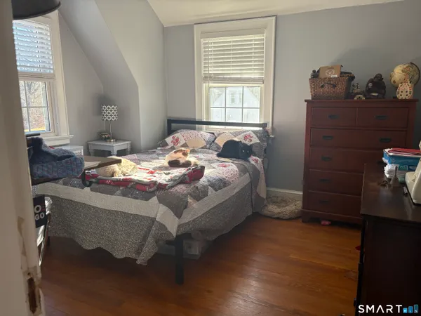 a bed sitting in a bedroom next to a window and dresser