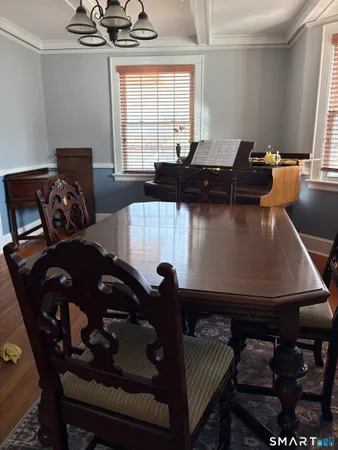 a black leather couch sitting in a living room next to a window
