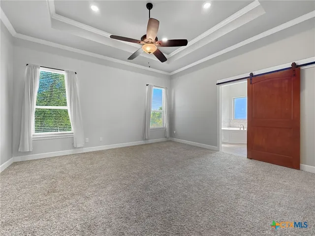 en empty room with windows and ceiling fan