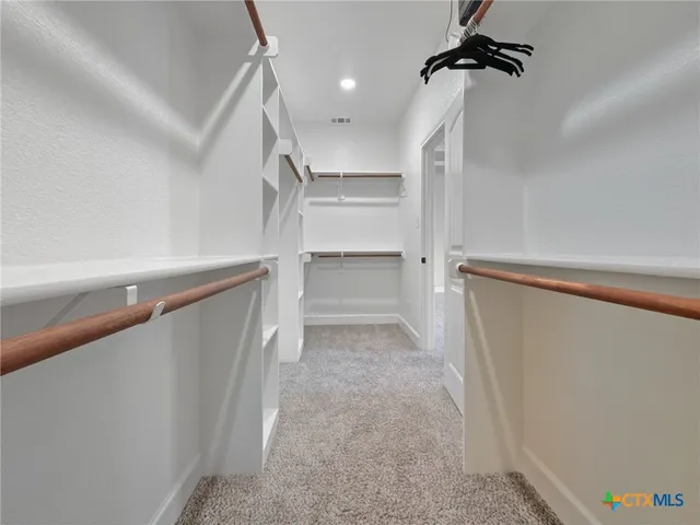 a view of walk in closet with empty racks