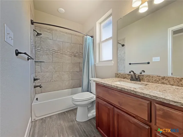a bathroom with a granite countertop sink toilet a bathtub and shower