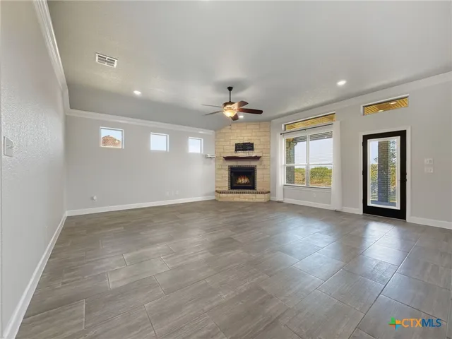 an empty room with a fireplace and window