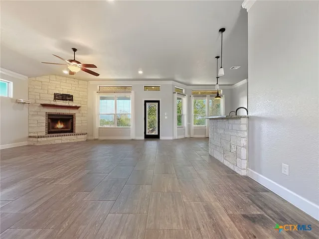 an empty room with wooden floor fireplace and a window