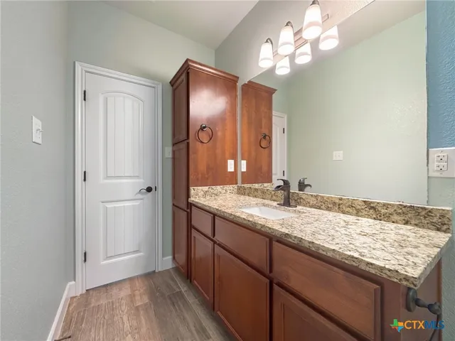 a bathroom with a granite countertop sink and a mirror