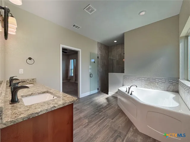 a spacious bathroom with a granite countertop sink and a mirror