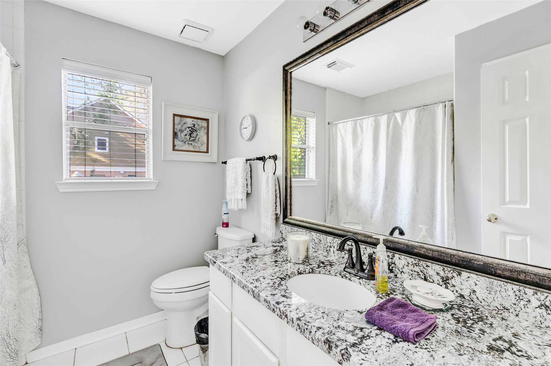 1014 North Rivershire Drive Conroe, TX 77304 - Photo 23 of 37 a bathroom with a granite countertop sink a mirror and a toilet