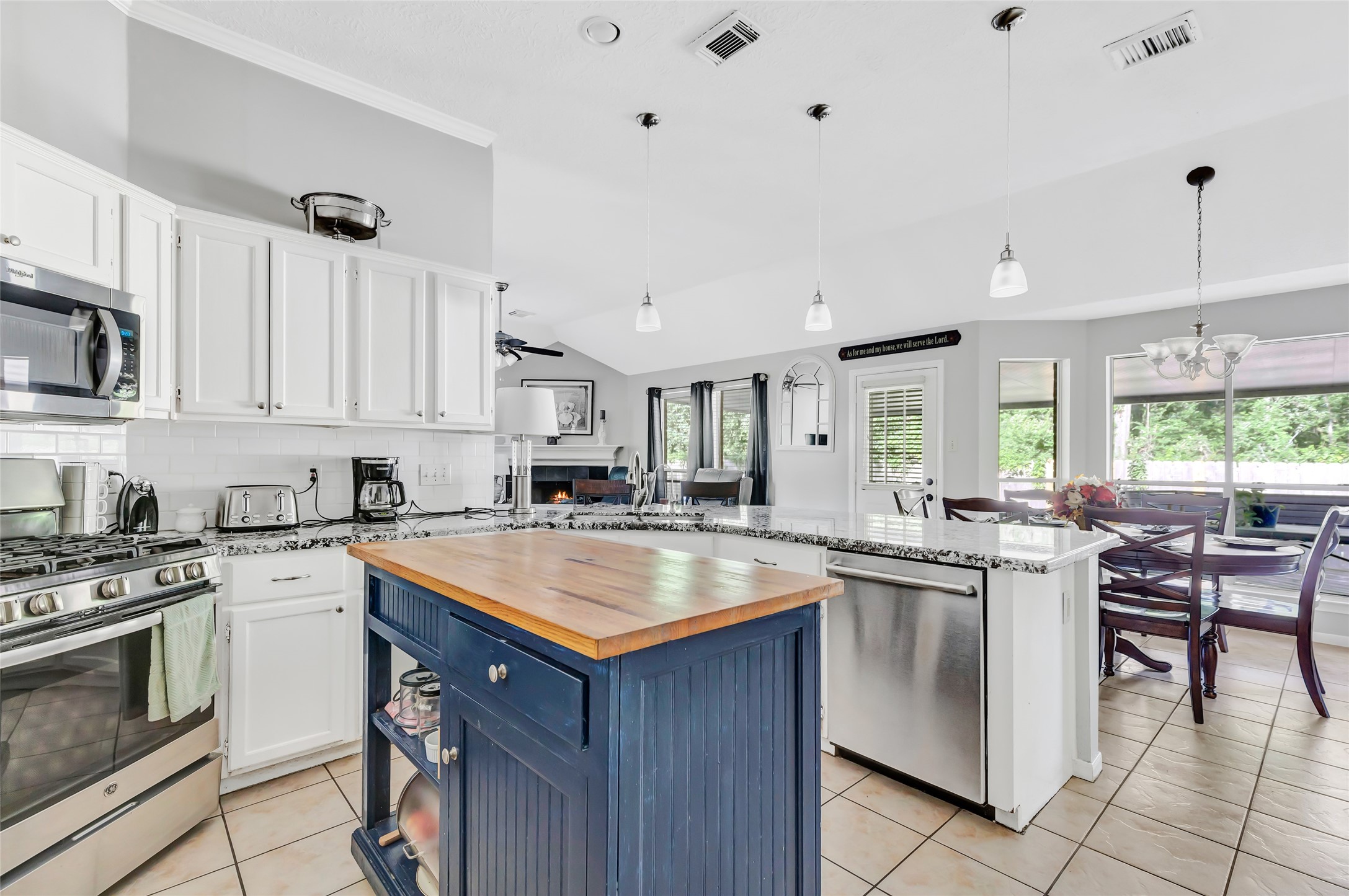 1014 North Rivershire Drive Conroe, TX 77304 - Photo 32 of 37 a kitchen with a stove a sink a microwave and chairs