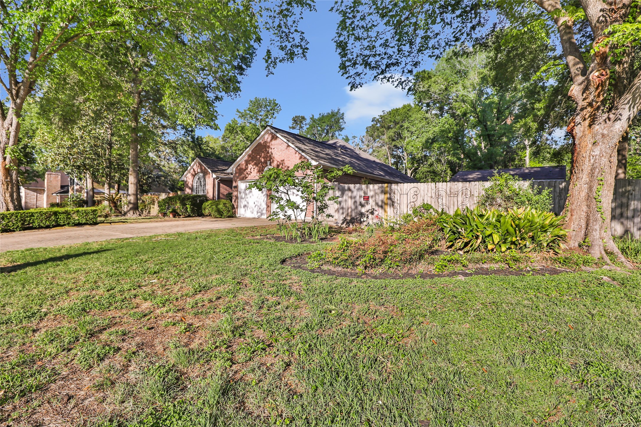 1014 North Rivershire Drive Conroe, TX 77304 - Photo 4 of 37 a view of a yard with plants and large trees
