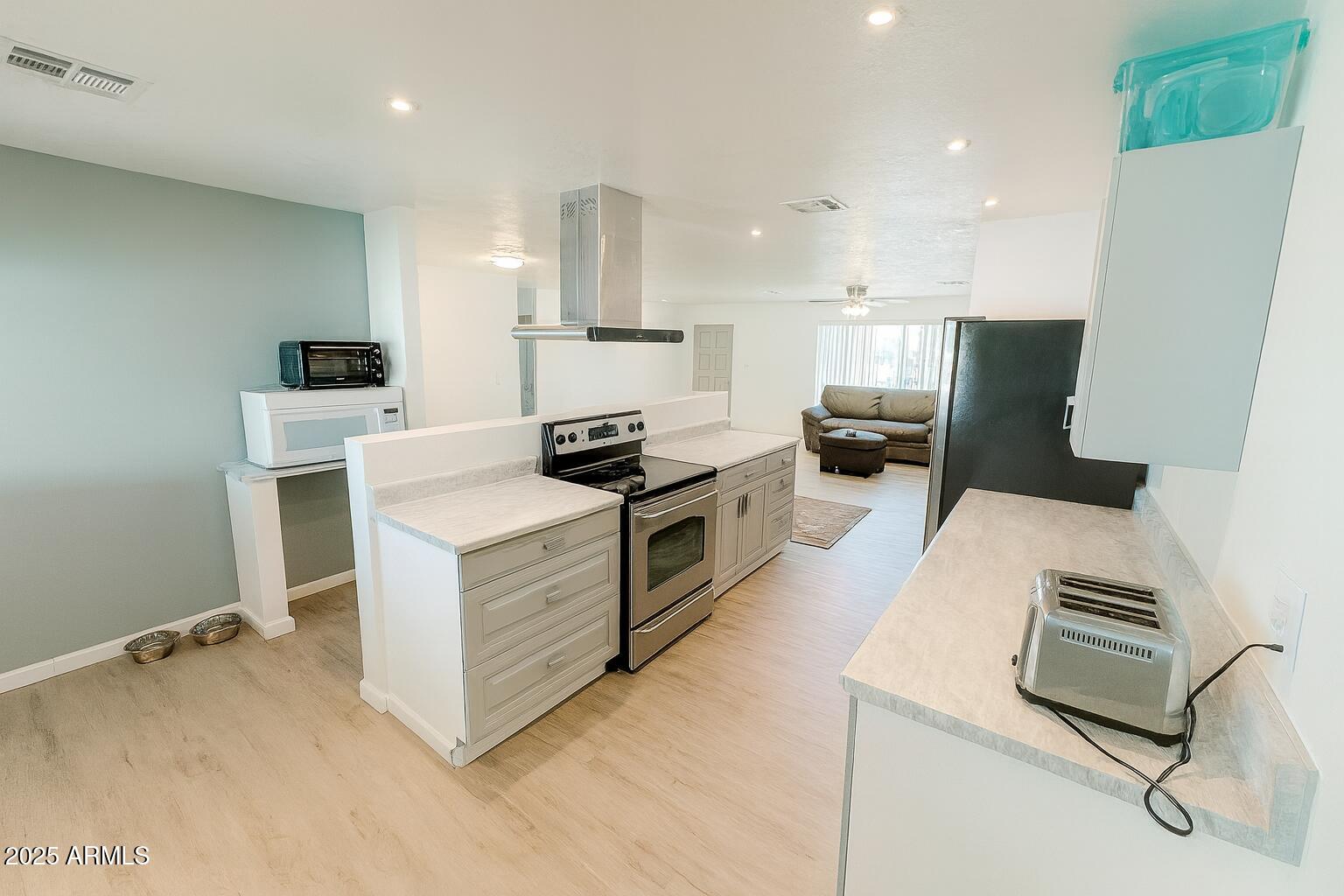 610 East Estevan Avenue Apache Junction, AZ 85119 - Photo 2 of 15 a kitchen with kitchen island white cabinets and white appliances