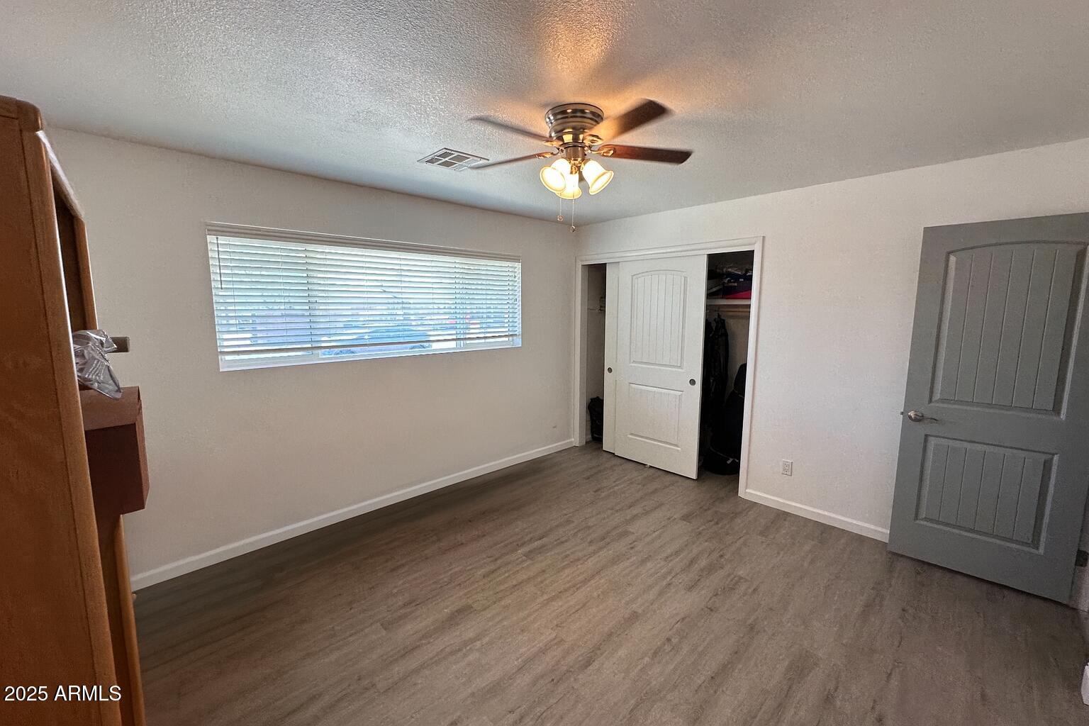 610 East Estevan Avenue Apache Junction, AZ 85119 - Photo 7 of 15 a view of an empty room with wooden floor and a window