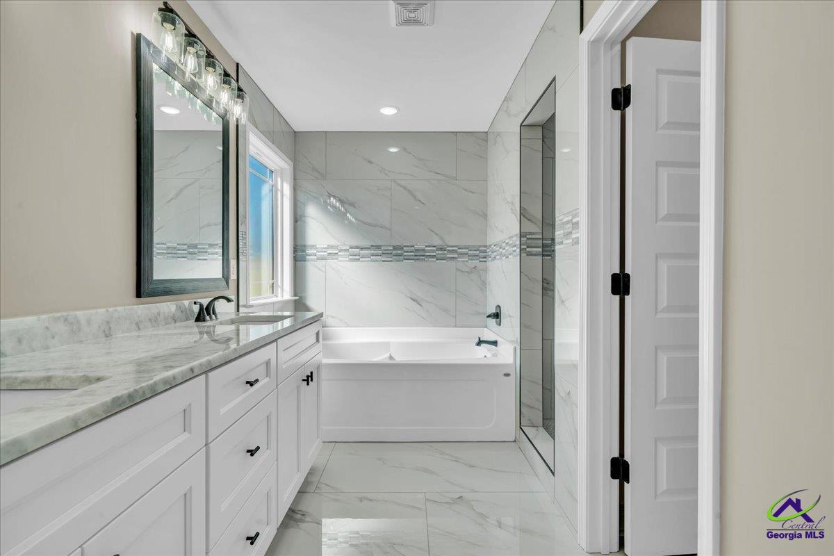 103 Early Drive Byron, GA 31008 - Photo 27 of 56 a bathroom with a granite countertop sink mirror and a bathtub
