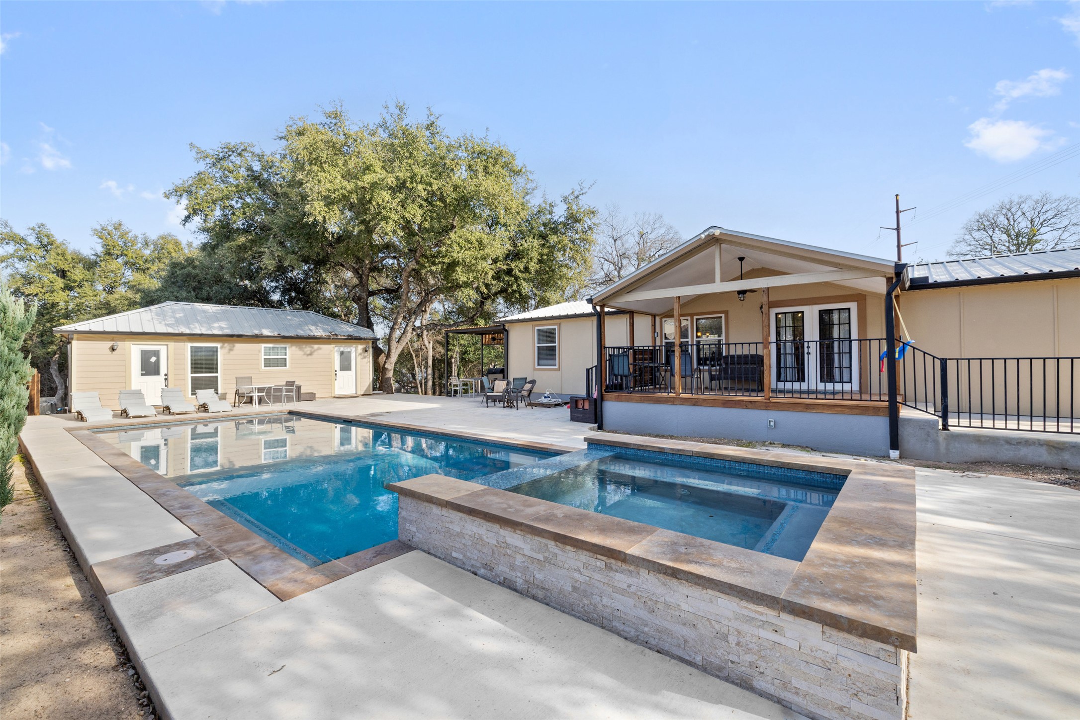 View of pool with french doors, a patio area, and a pool with connected hot tub