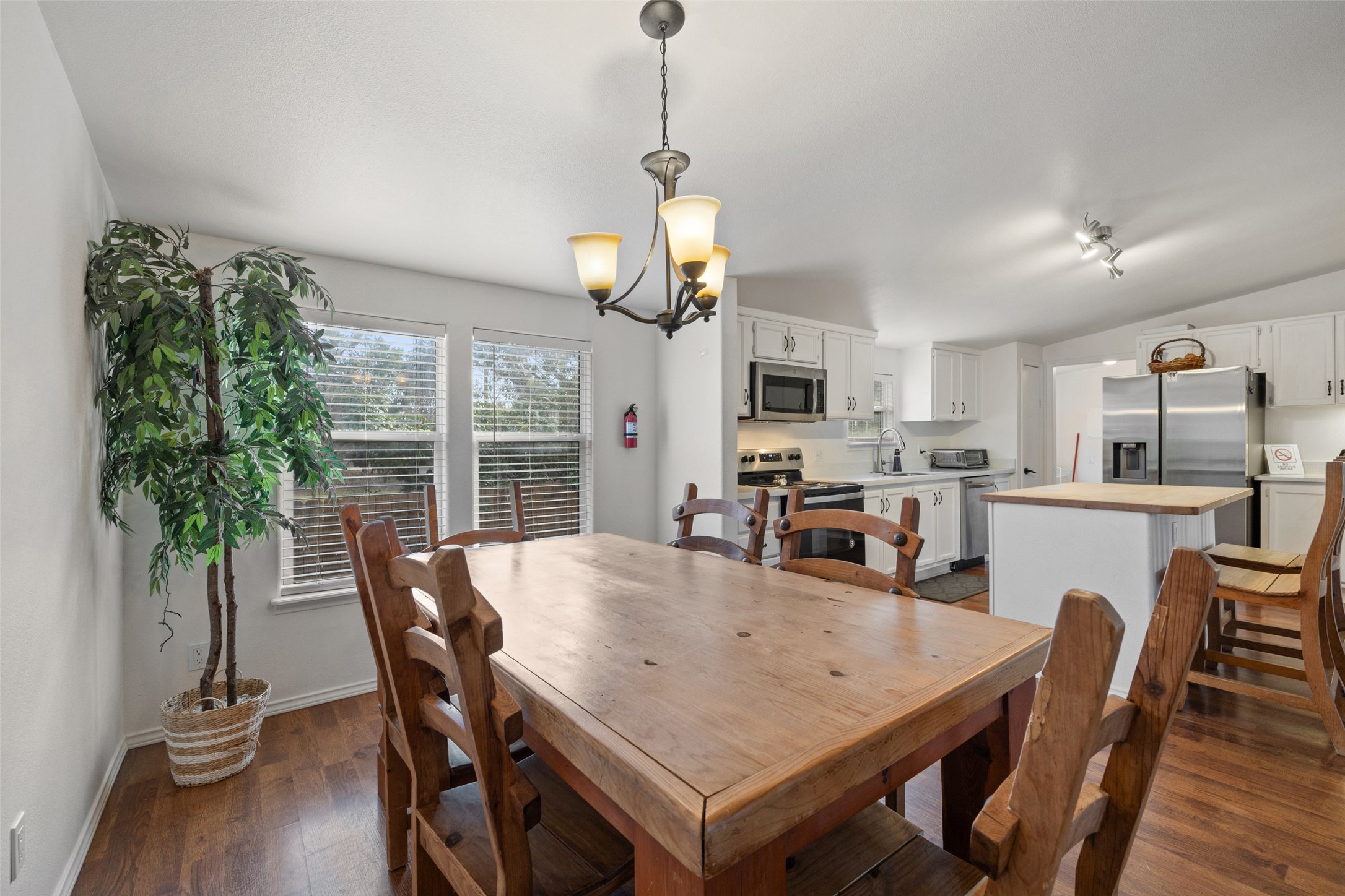 5519 Hiline Road Austin, TX 78734 - Photo 12 of 40 Dining space with dark wood finished floors, baseboards, and an inviting chandelier