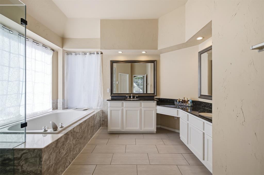 1911 New Haven Road Grapevine, TX 76051 - Photo 11 of 39 Ensuite bathroom remodeled with new shower tile, tub surround and 12x24 floor tiles.