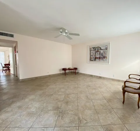 a view of room with workspace and ceiling fan
