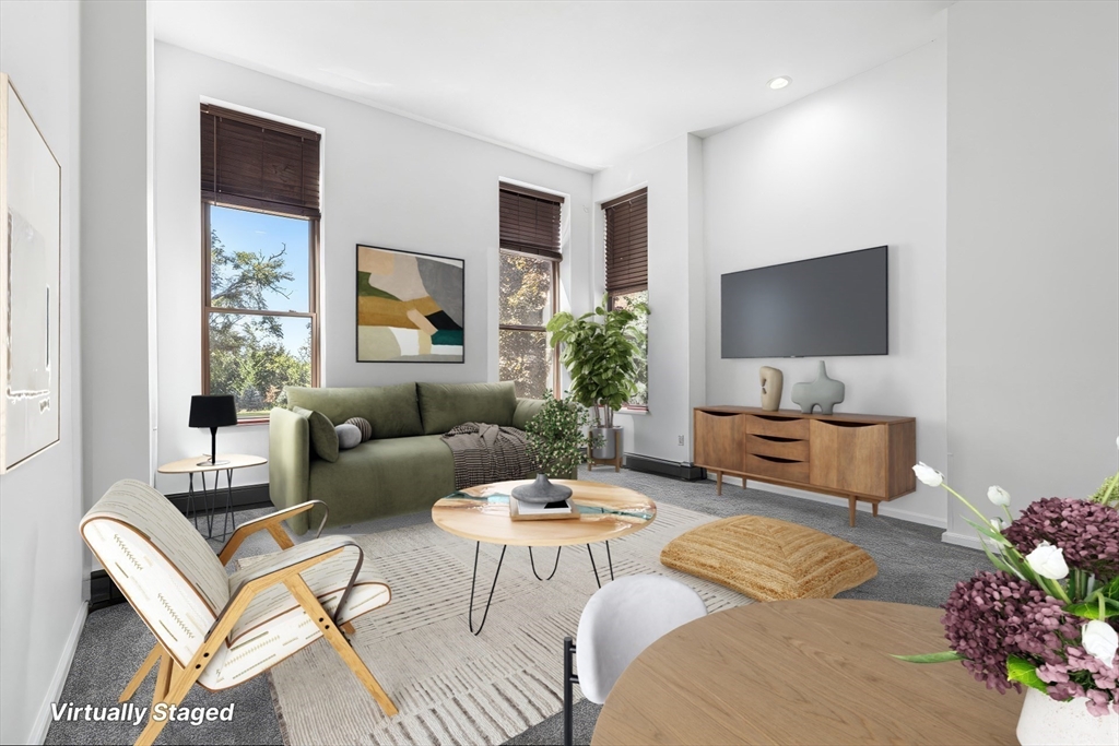 141 Savin Hill Avenue, Unit A22 Boston, MA 02125 - Photo 1 of 15 a living room with furniture a flat screen tv and a large window