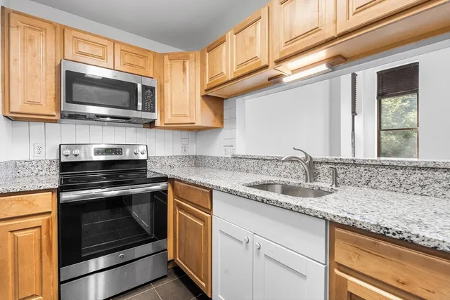 a kitchen with stainless steel appliances granite countertop a sink and a microwave