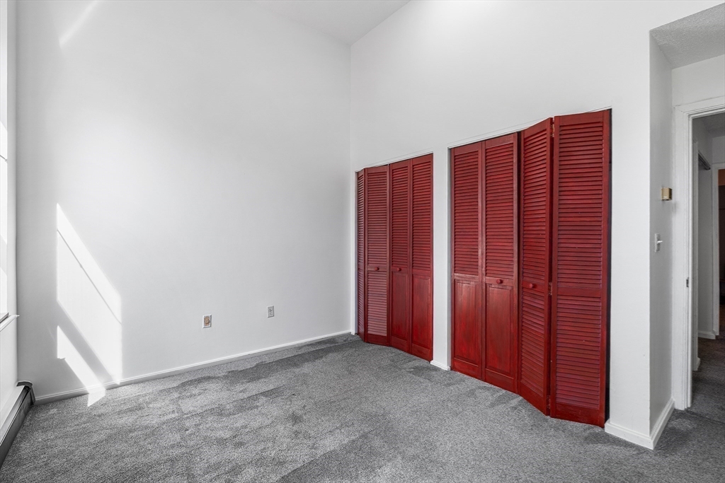 141 Savin Hill Avenue, Unit A22 Boston, MA 02125 - Photo 9 of 15 an empty room with a wooden door
