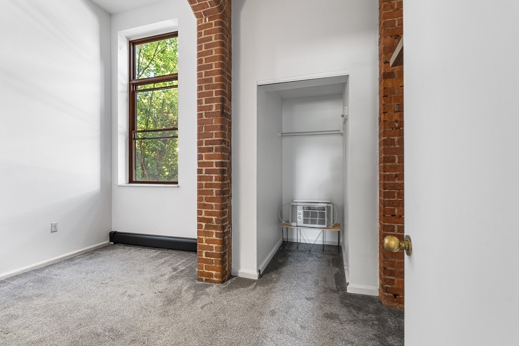 141 Savin Hill Avenue, Unit A22 Boston, MA 02125 - Photo 10 of 15 an empty room with windows and closet