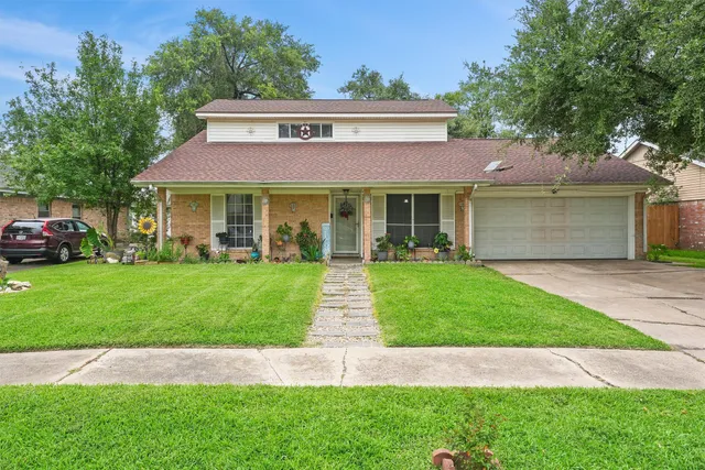 a front view of a house with a garden and plants