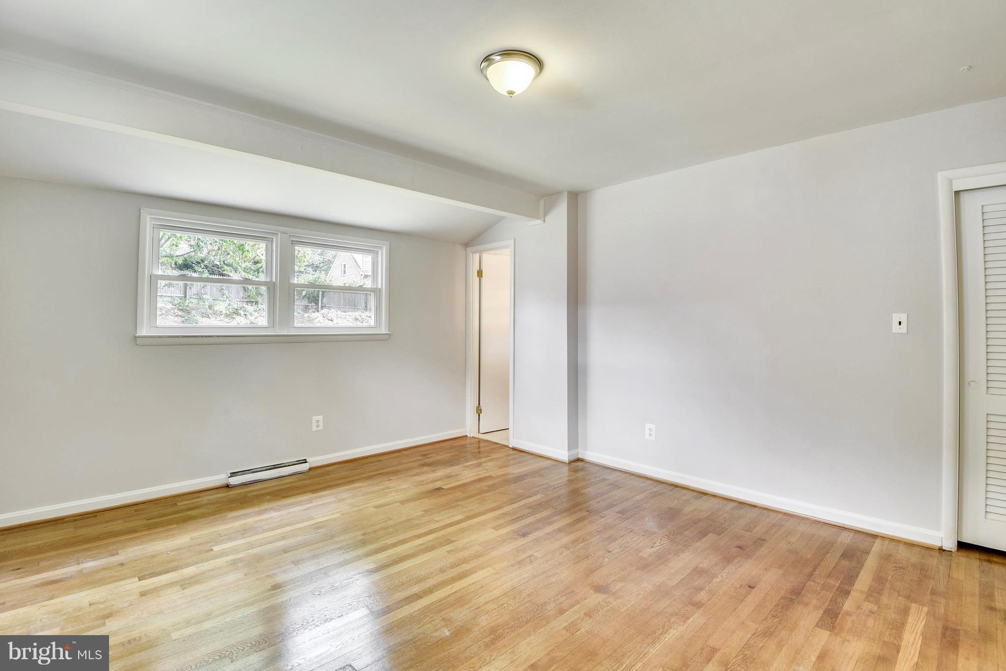 9005 Bradford Road Silver Spring, MD 20901 - Photo 13 of 28 a view of an empty room with wooden floor and a window