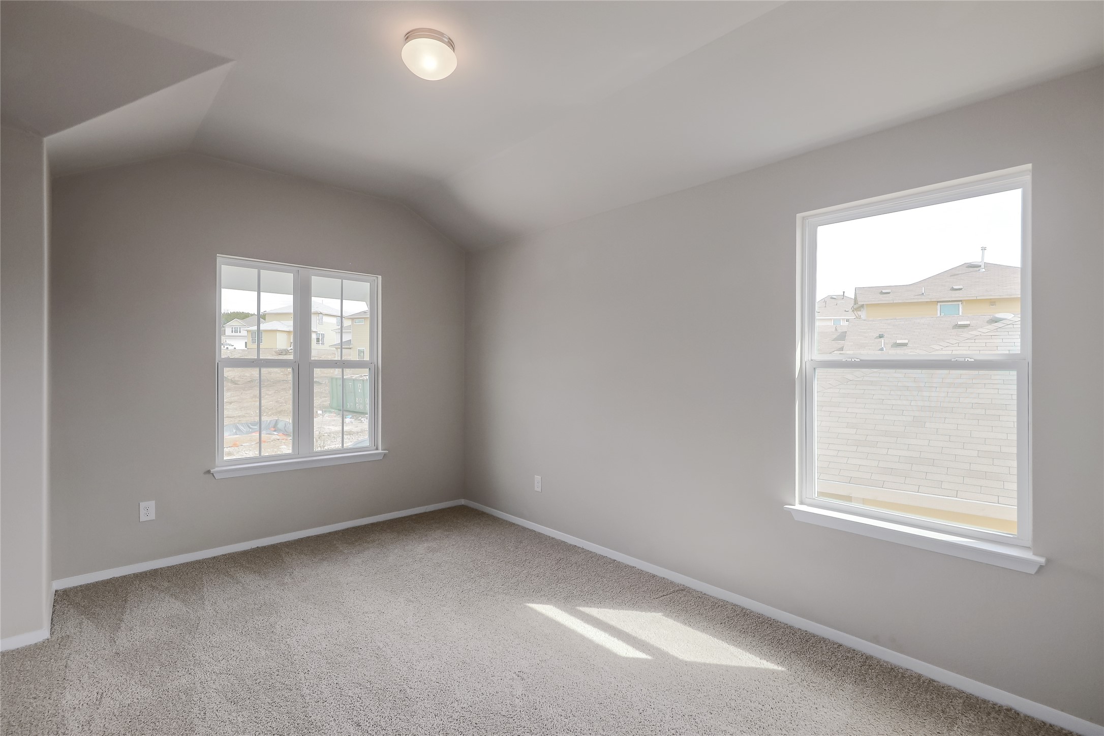 11416 Milano Drive Austin, TX 78747 - Photo 16 of 25 Spare room featuring carpet flooring, plenty of natural light, and lofted ceiling