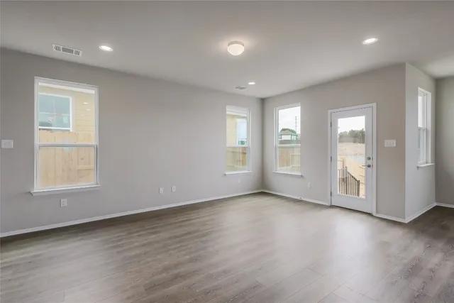 a large kitchen with kitchen island a sink dishwasher a stove and a refrigerator with wooden floor