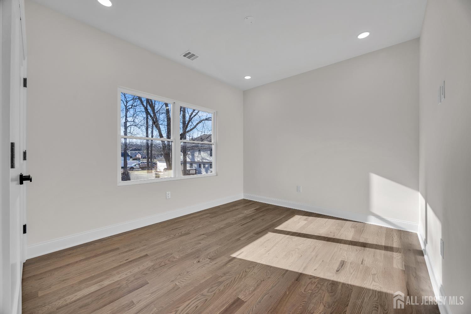 265 West Prescott Avenue Edison, NJ 08820 - Photo 32 of 56 a view of an empty room with a window and wooden floor