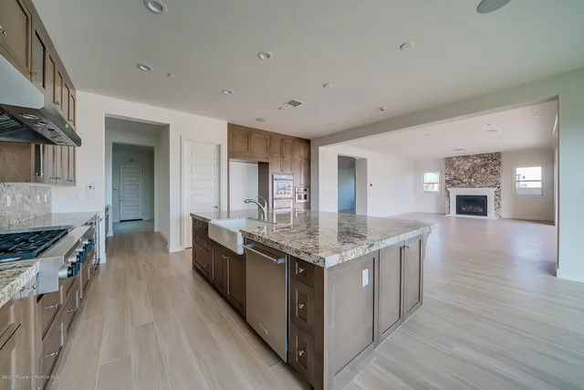 an empty room with wooden floor fireplace and windows