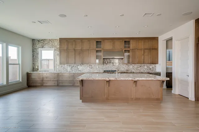 a kitchen with granite countertop a sink a counter space appliances and cabinets