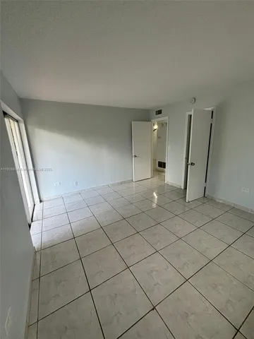 an empty room with a fireplace and cabinet