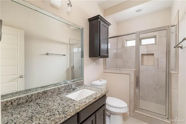a bathroom with a granite countertop sink toilet and shower