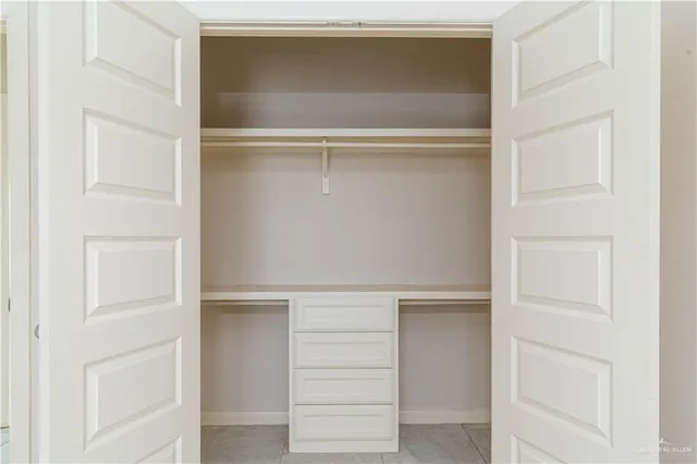 a view of walk in closet with empty racks
