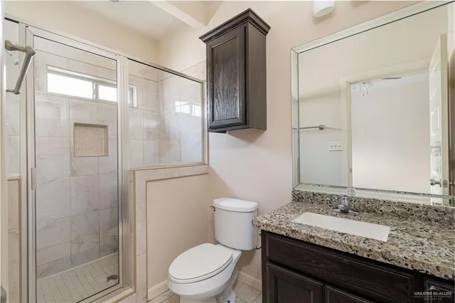 a bathroom with a granite countertop sink toilet and shower