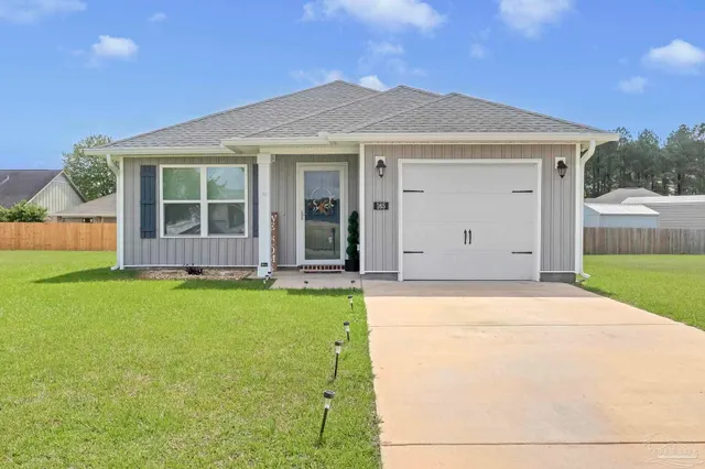 a front view of a house with a garden and yard