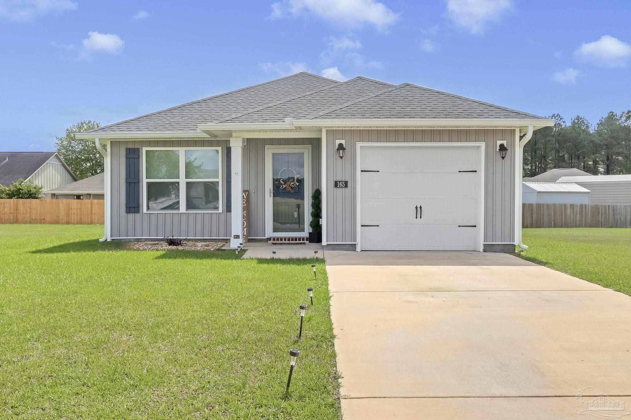 a front view of a house with a garden and yard