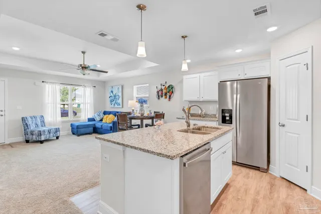 a kitchen with stainless steel appliances granite countertop a sink dishwasher and cabinets with wooden floor