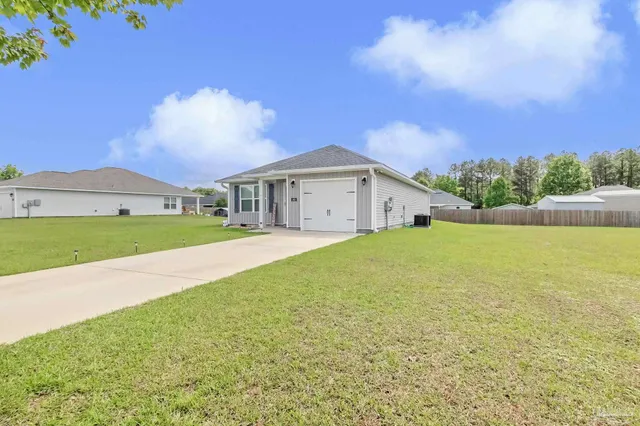 a front view of a house with a garden and yard