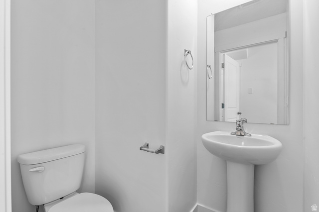 1907 East 640th North, Unit 1225 Salem, UT 84653 - Photo 2 of 20 Pedestal sink with chrome faucet, complemented by a rectangular mirror and white ceramic toilet