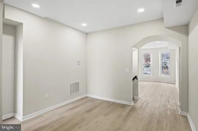 an empty room with wooden floor and mirror