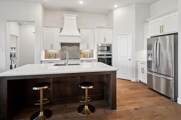 a kitchen with white cabinets sink and stainless steel appliances