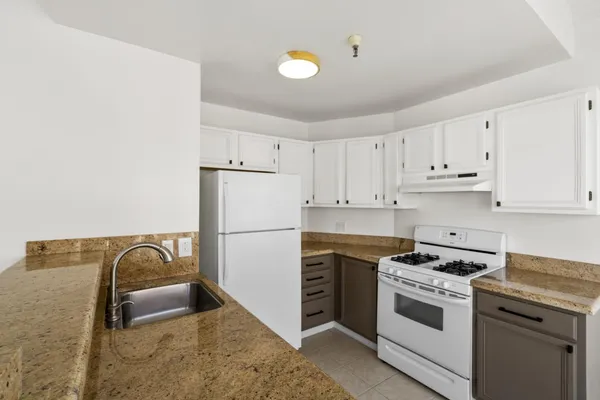 a kitchen with a refrigerator and a stove top oven