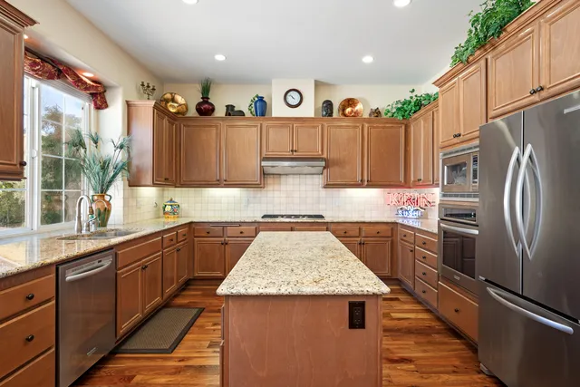 a kitchen with a refrigerator a sink and wooden cabinets